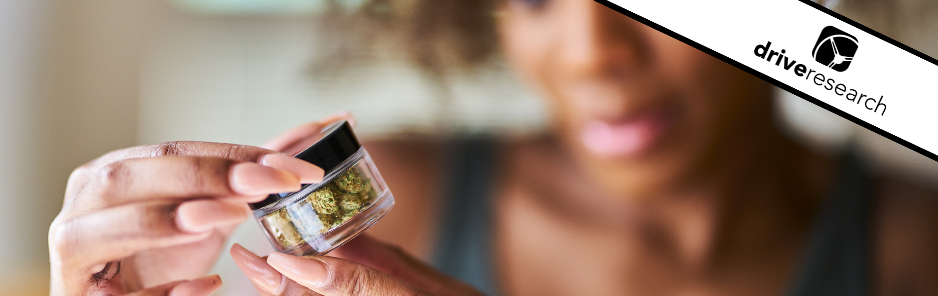 african woman looking at cannabis bottle close up