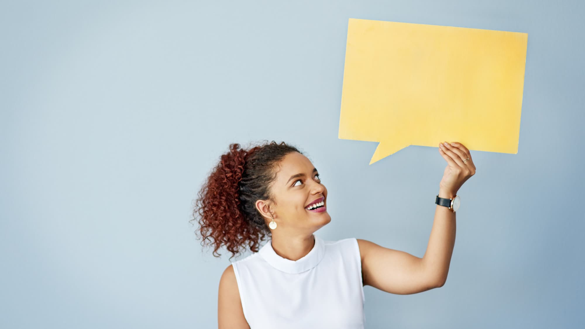 woman holding yellow paper comment bubble