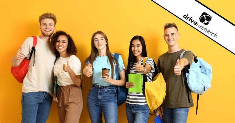 Students with book bags in a row doing a thumbs up