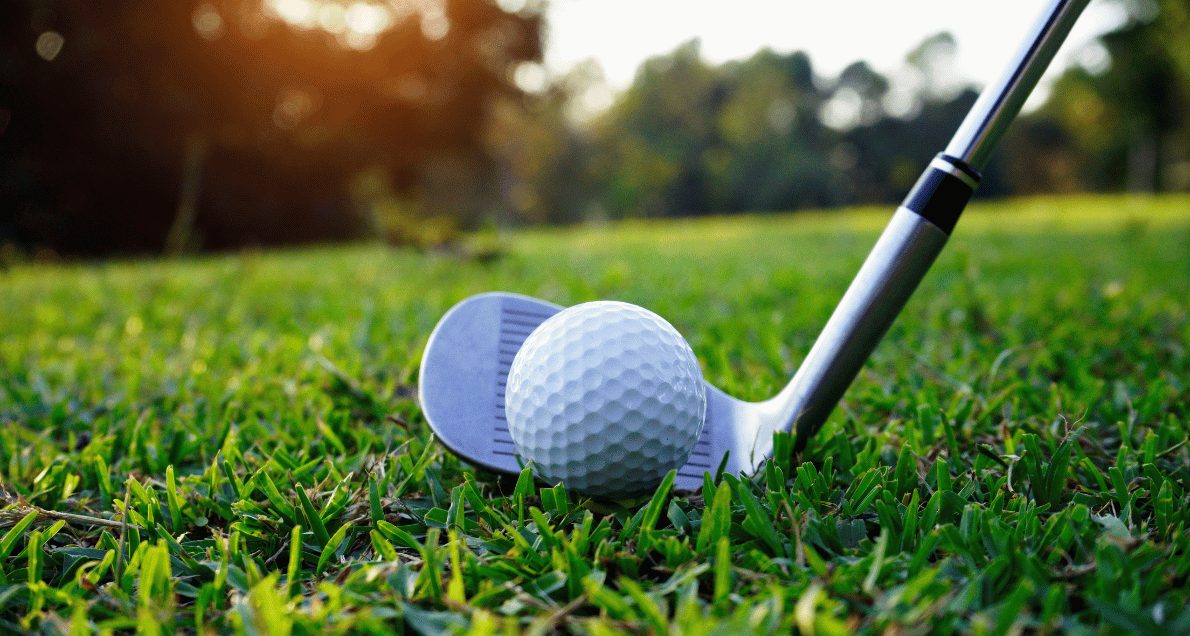 Golf ball and golf club on grass