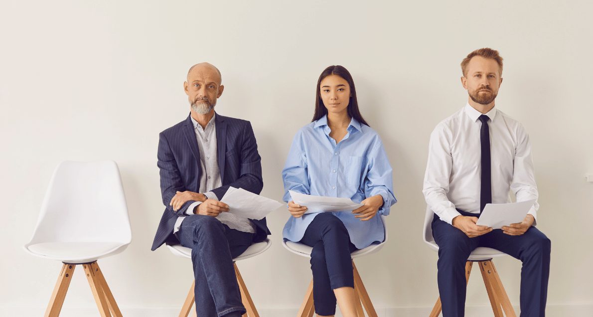 Three Multiracial Candidates of Different Ages Sitting on Chairs Waiting for Job Interview