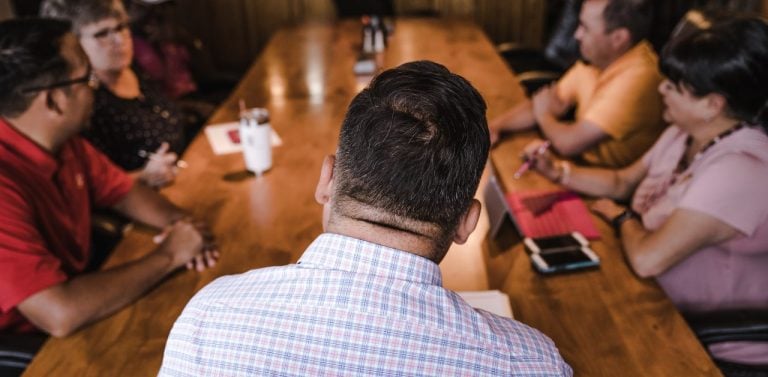 Shallow Focus Photography Of Man Facing Backward in Focus Group