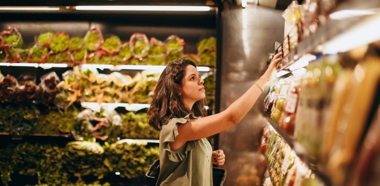 Woman Picking Out Items Off the Shelf At the Store - Featured Image