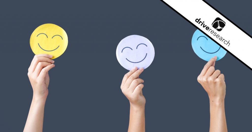 People Holding Smile or Happy Emoticons in Hands Against Gray Background - Drive Research watermark