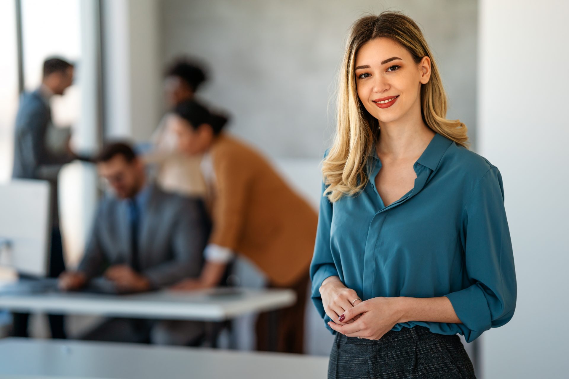 Portrait of business woman in front of colleagues at a desk