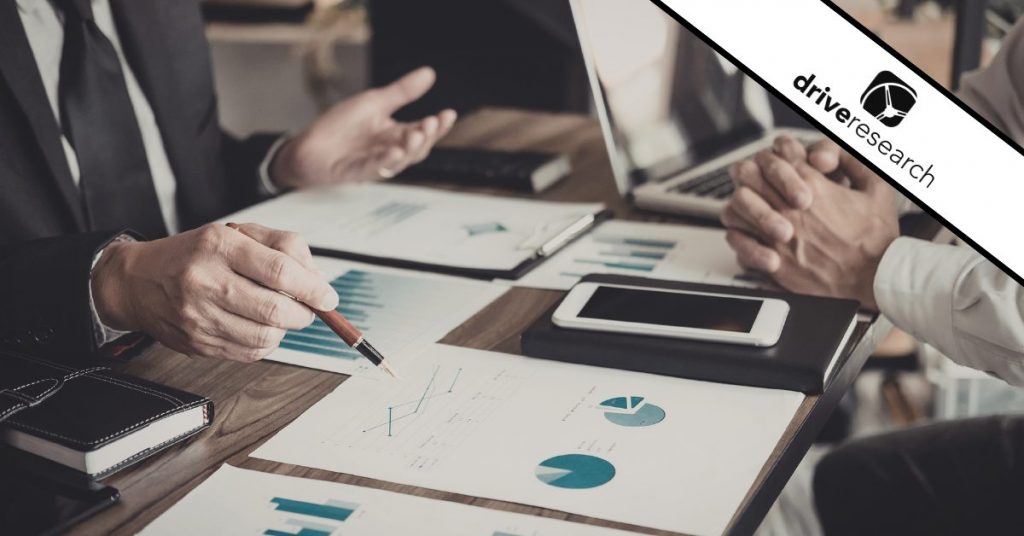 two people working at a desk with papers and computers looking at advanced analytics for an education brand