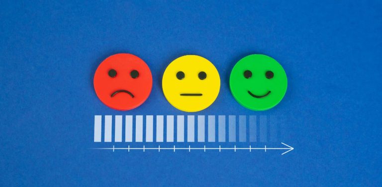 Faces with emotions to assess customer satisfaction on blue background.
